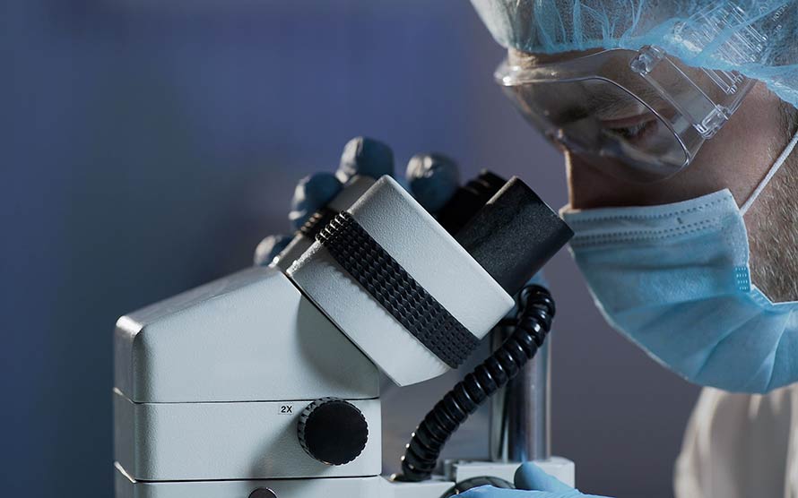 A researcher using a microscope