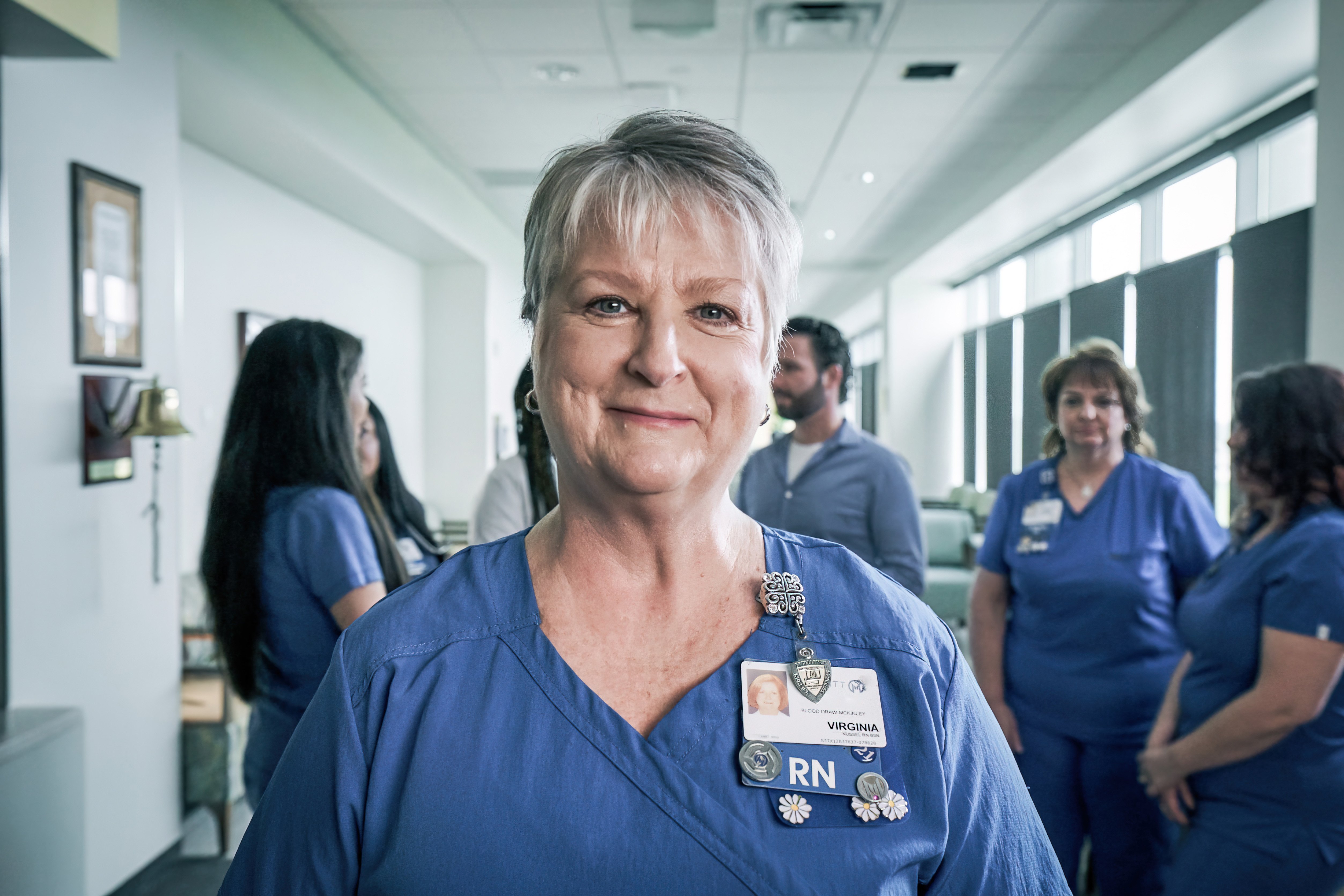Oncology nurse at Moffitt Cancer Center smiling for the camera with a team of nurses behind her.