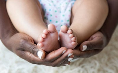 mother's hands holding baby's feet