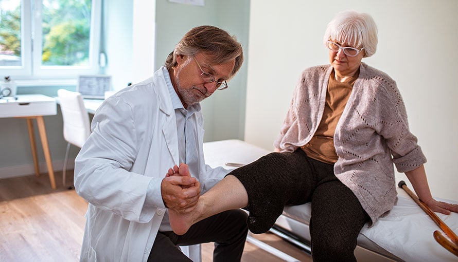 Doctor checking a woman's leg bone