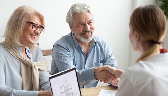a woman shakes another woman's hand after receiving an endowment gift