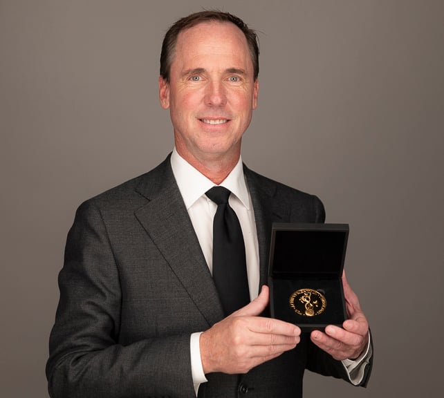 photo of Dr. Sawyer holding gold medal