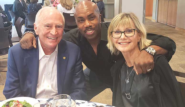 From left, H. Lee Moffitt, singer/songwriter Paul Anthony and Olivia Newton-John attend a Moffitt Board of Advisors meeting to discuss how to better advocate for prevention, early detection and cancer research.