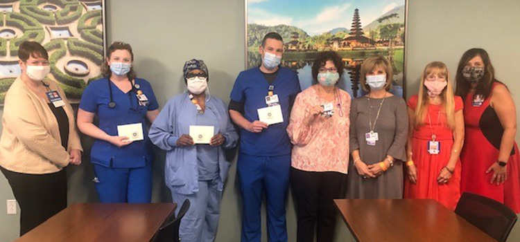 Team members wear masks while receiving the PFAC Award of Excellence