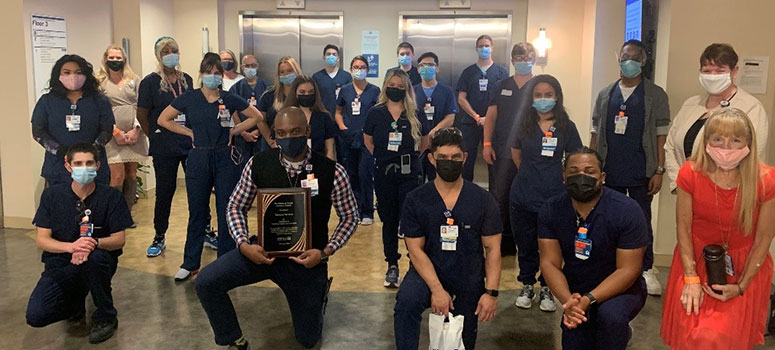 Team members from the Department of Transport Services accept the PFAC Award of Excellence while wearing masks and maintaining social distance.