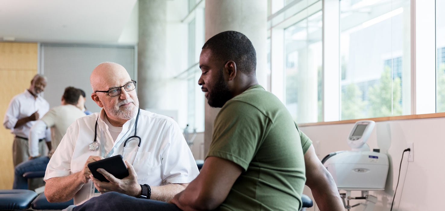 A doctor talk to a man about common signs of testicular cancer