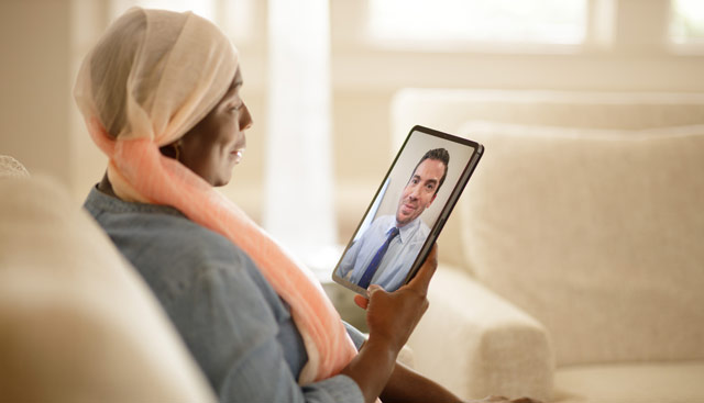 Woman talking to doctor via tablet