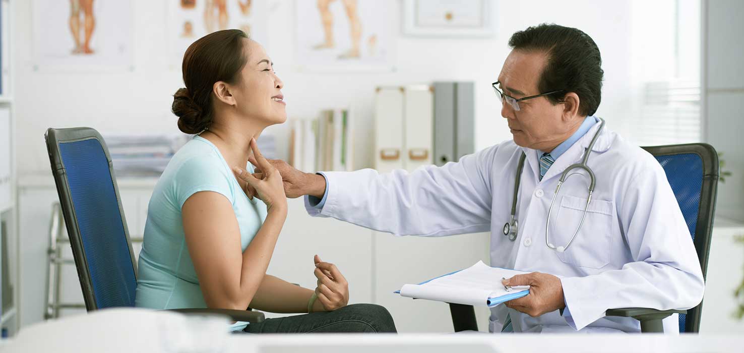 A doctor exams a woman's throat for early signs of esophageal cancer