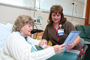 A Moffitt nurse helps a patient with paper work