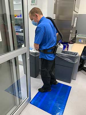 Before entering the infusion pharmacy, the Environmental Services team steps on a sticky floor pad to eliminate contaminants on their shoes.