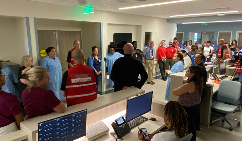 Tampa Police Chief Lee Bercaw, center in black, debriefs the group during the active shooter drill. Tampa Police and Moffitt had a unique opportunity to practice their response at Moffitt McKinley Hospital before it opens in late July.
