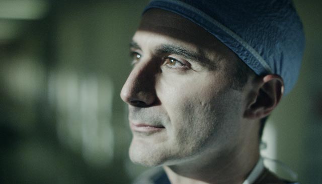 Doctor looking off into distance with scrub cap on thinking about a pancoast tumor surgery