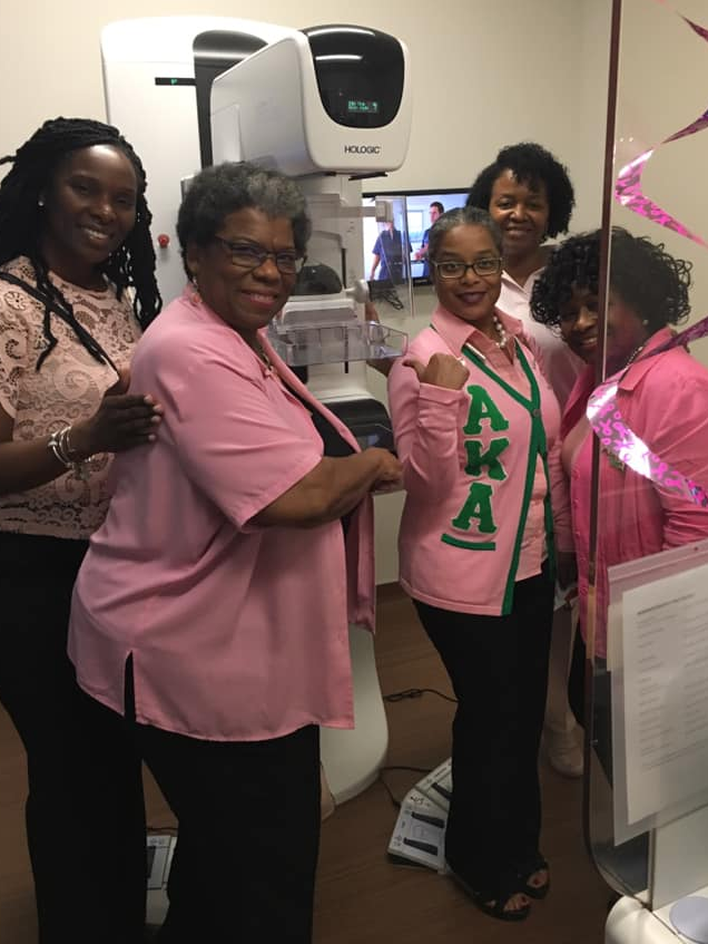 women around a mammogram machine