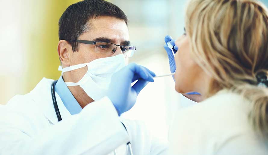 Doctor examining patient's mouth for oral cancer