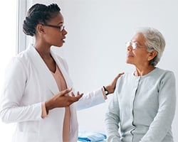 Doctor speaking with senior adult about cancer