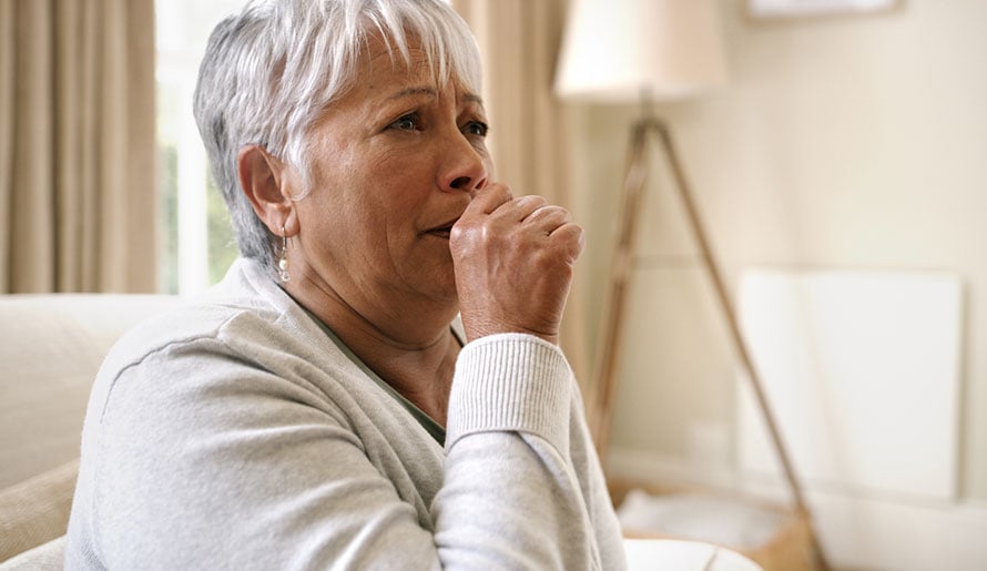 woman coughing, an early sign of lung cancer