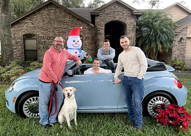 Becky and Todd, with their two sons, Luke and Caleb, showing off her Volkswagen Beetle.