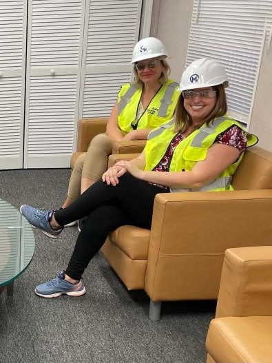 Photo of Andrea Cabrera and Amy Ozier wearing hard hats and yellow vests