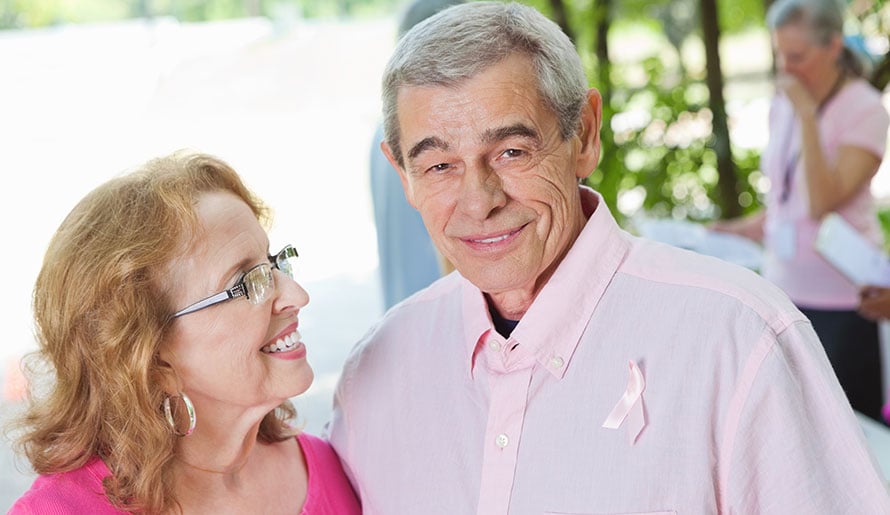 Male breast cancer patient wearing pink ribbon and shirt