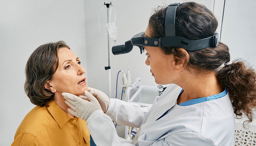 Doctor checking patient's tongue for signs of cancer