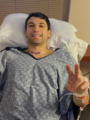 Photo of Danny New wearing a gown in his hospital bed