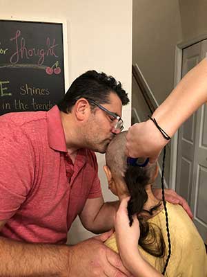 Rosa Fragello's family helps her shave her head