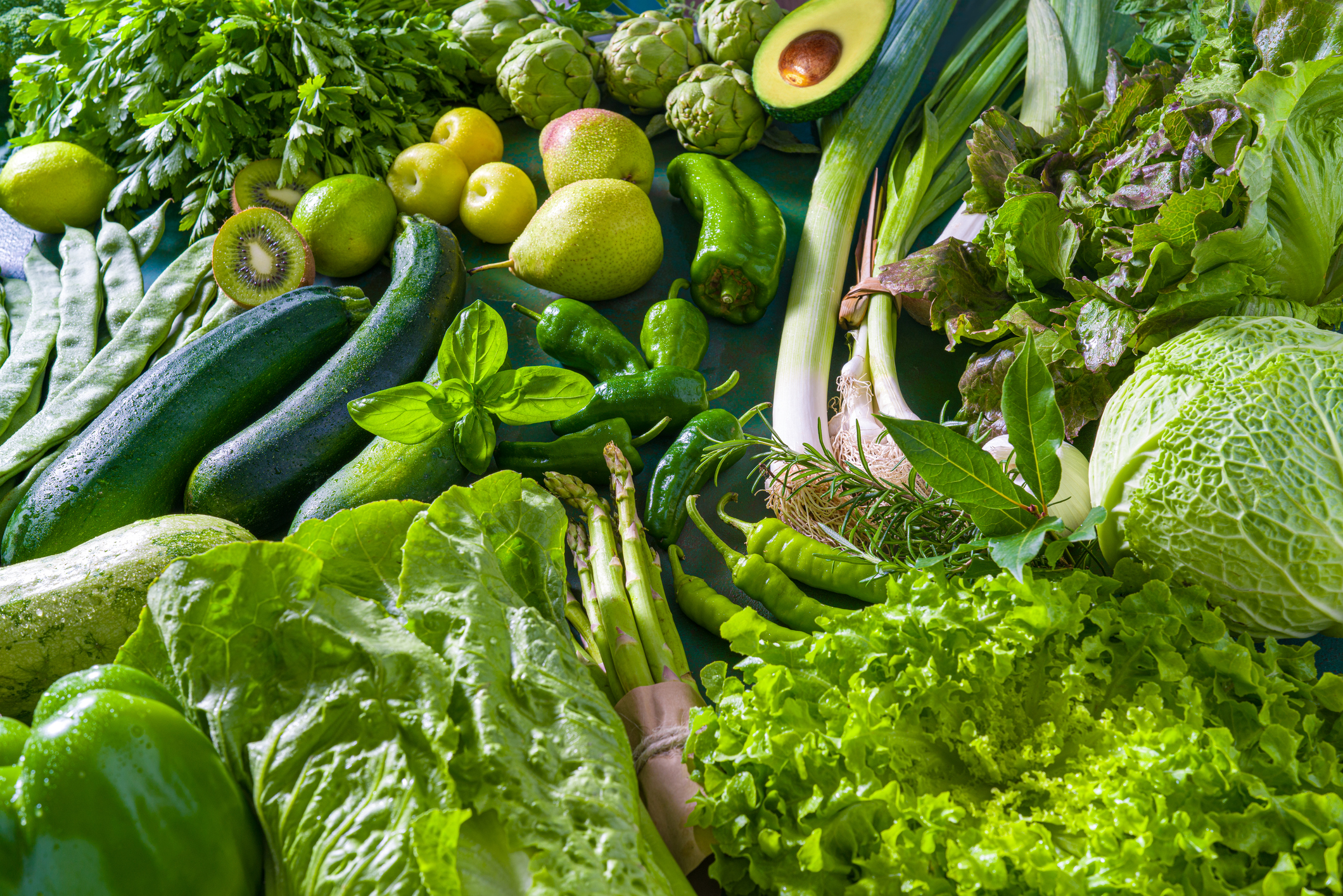 Pile of green vegetables including avocado, lettuce, kale and more