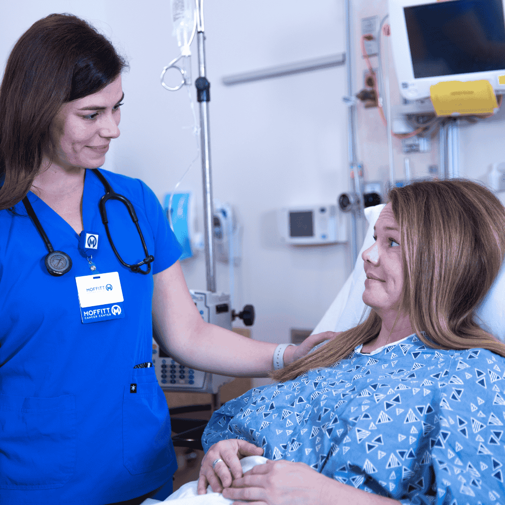Nurse taking care of patient in bed.