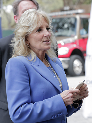 Dr. Biden holds her mask in her hands while speaking to the press.
