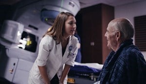 A radiation oncologist talks to a patient