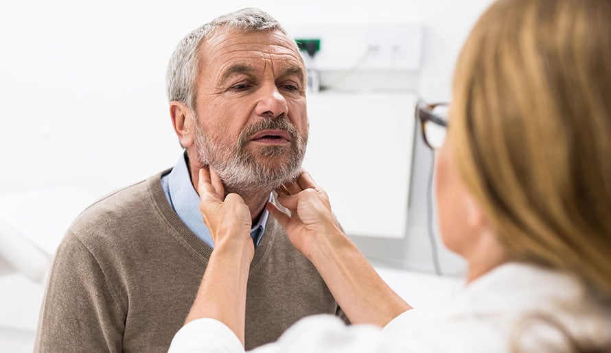 doctor examining throat for adenoid squamous cell carcinoma