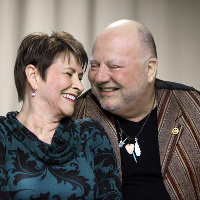 Image of Juli, colon cancer survivor and her caregiver husband, smiling at each other.